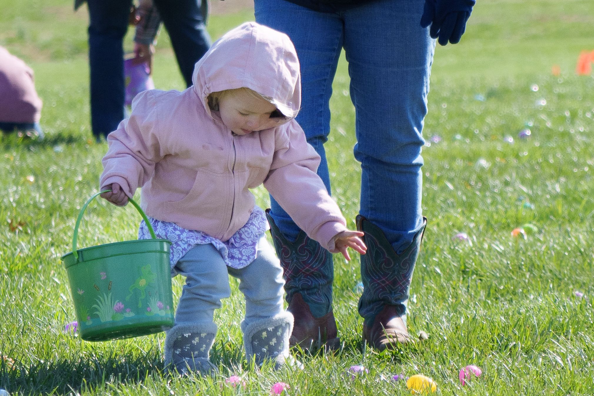 Photo of a girl wearing a heavy coat reaching for an egg