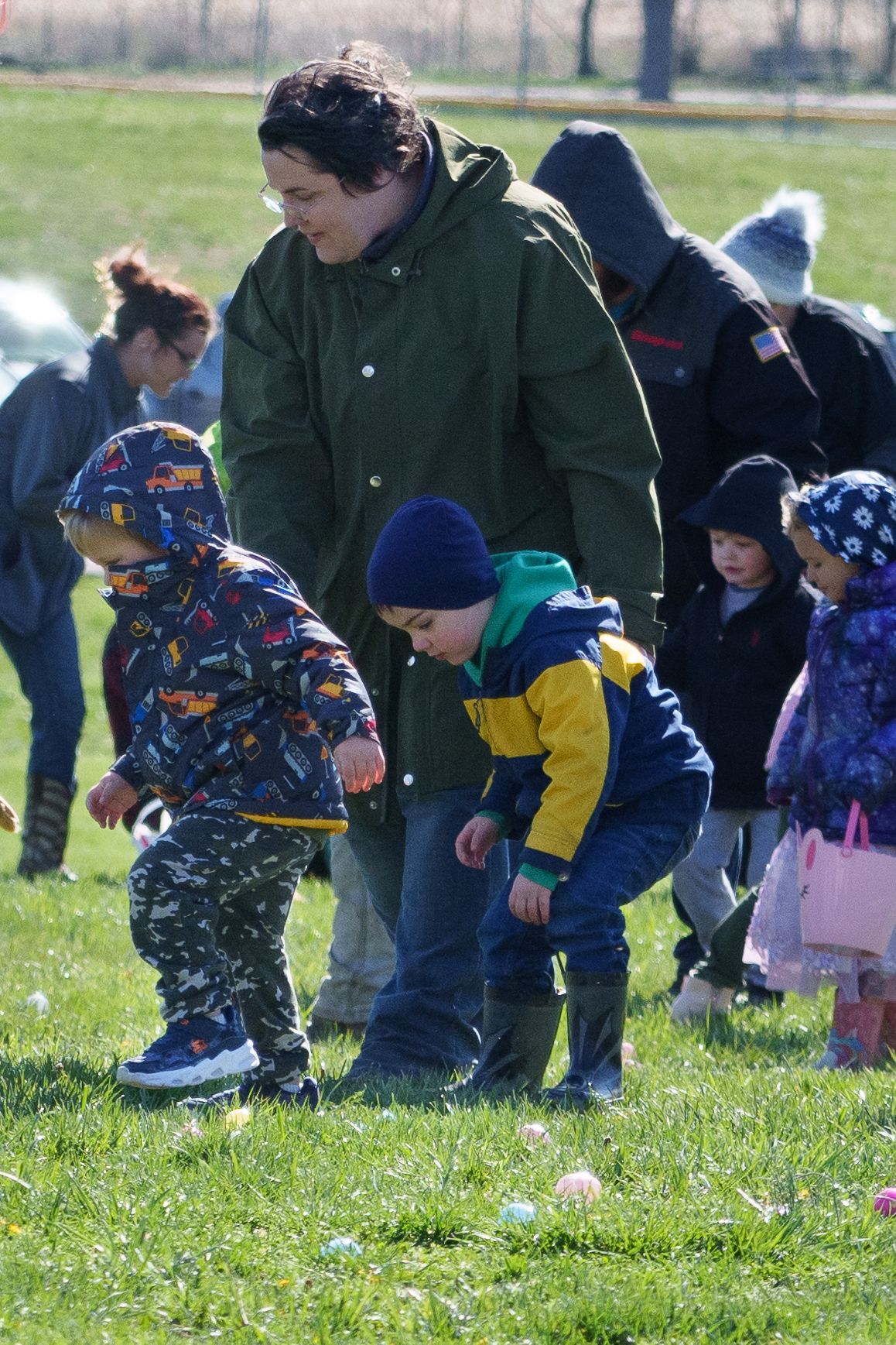 Photo of a child picking up a plastic egg