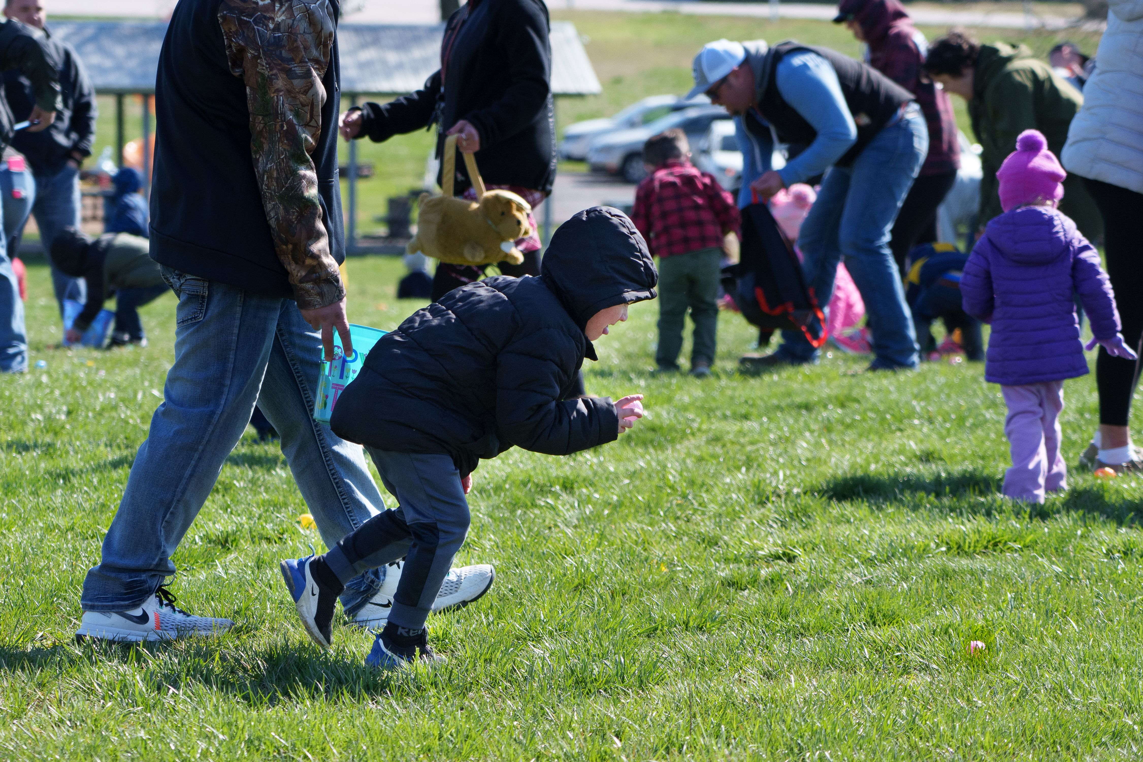 Photo of a child picking up a plastic egg