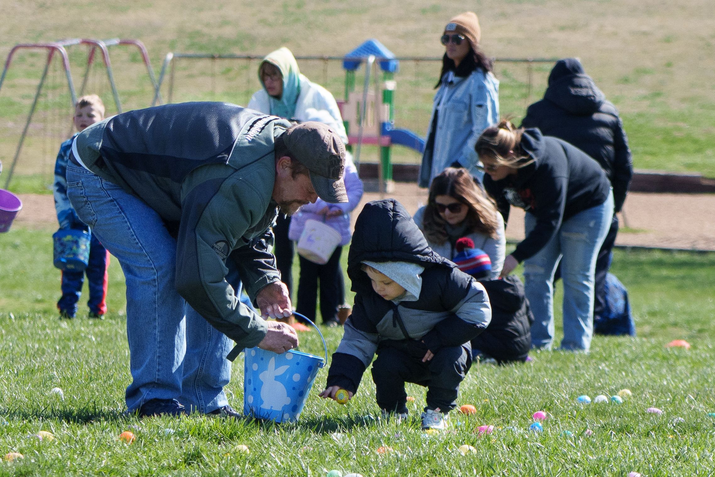 Photo of a child picking up a plastic egg