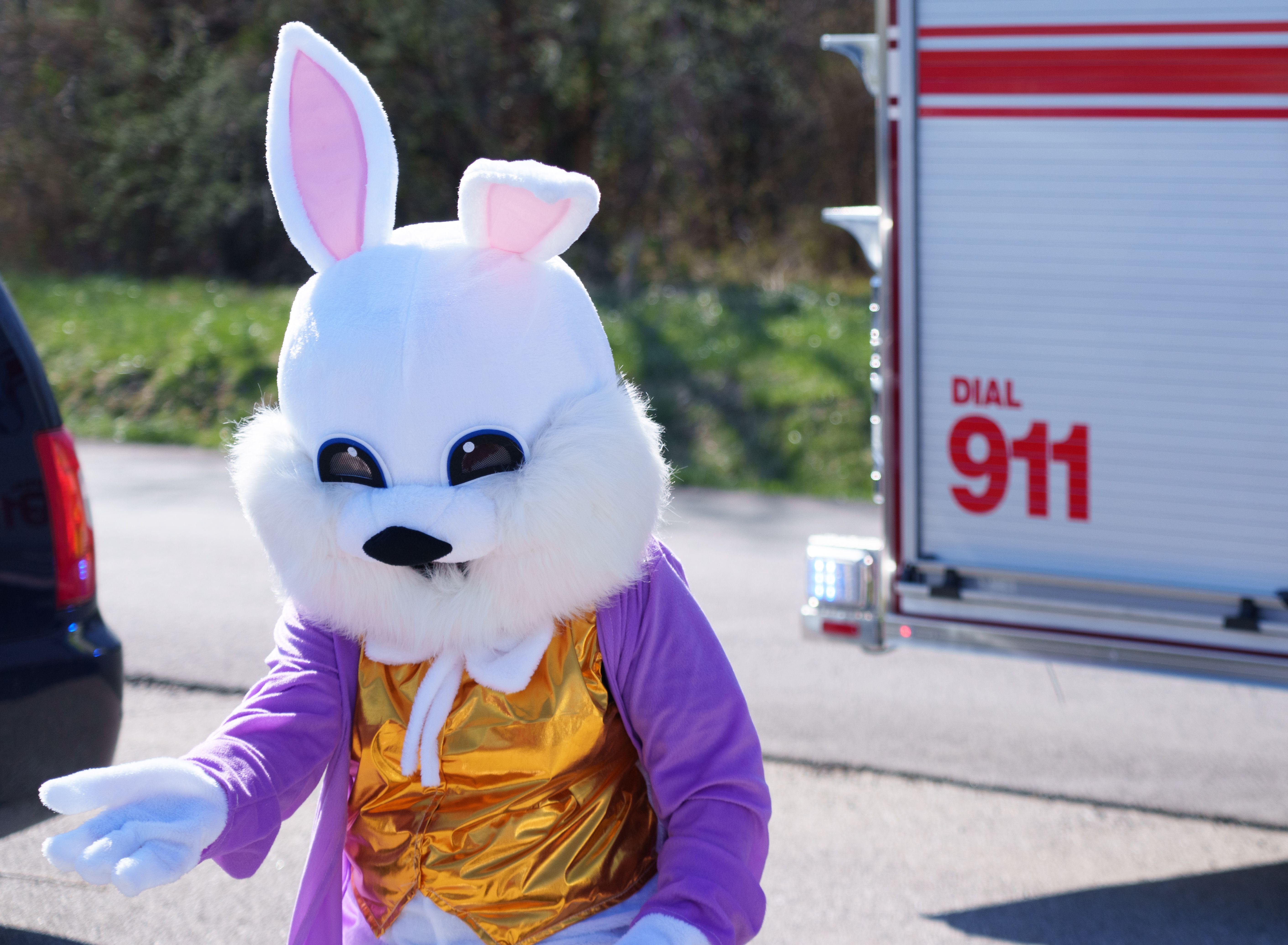 Photo of an Easter Bunny mascot in front of a fire trick showing 'Dial 911' on the side