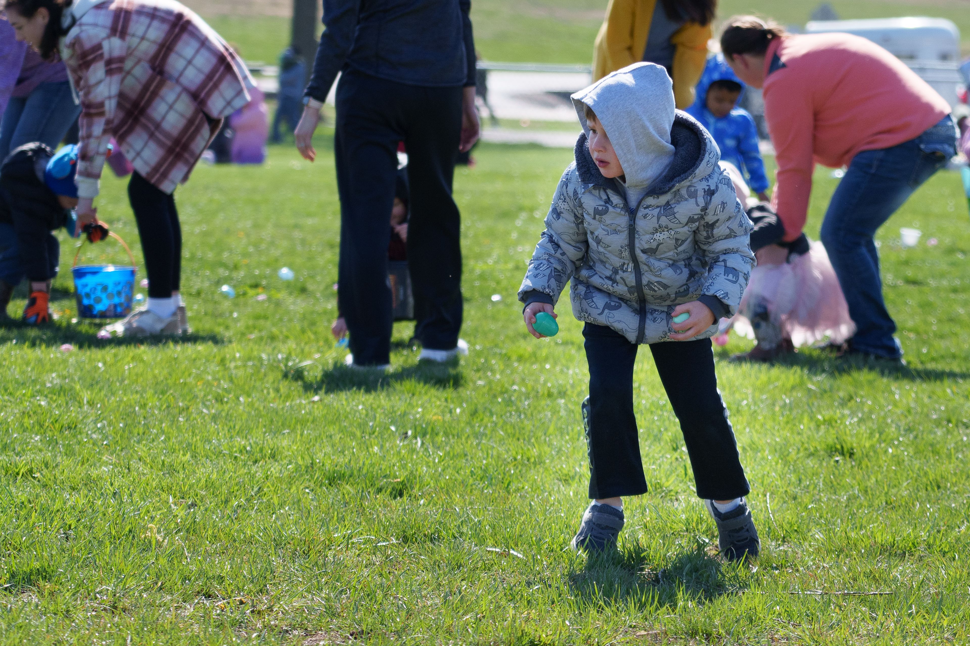 Photo of a child picking up a plastic egg