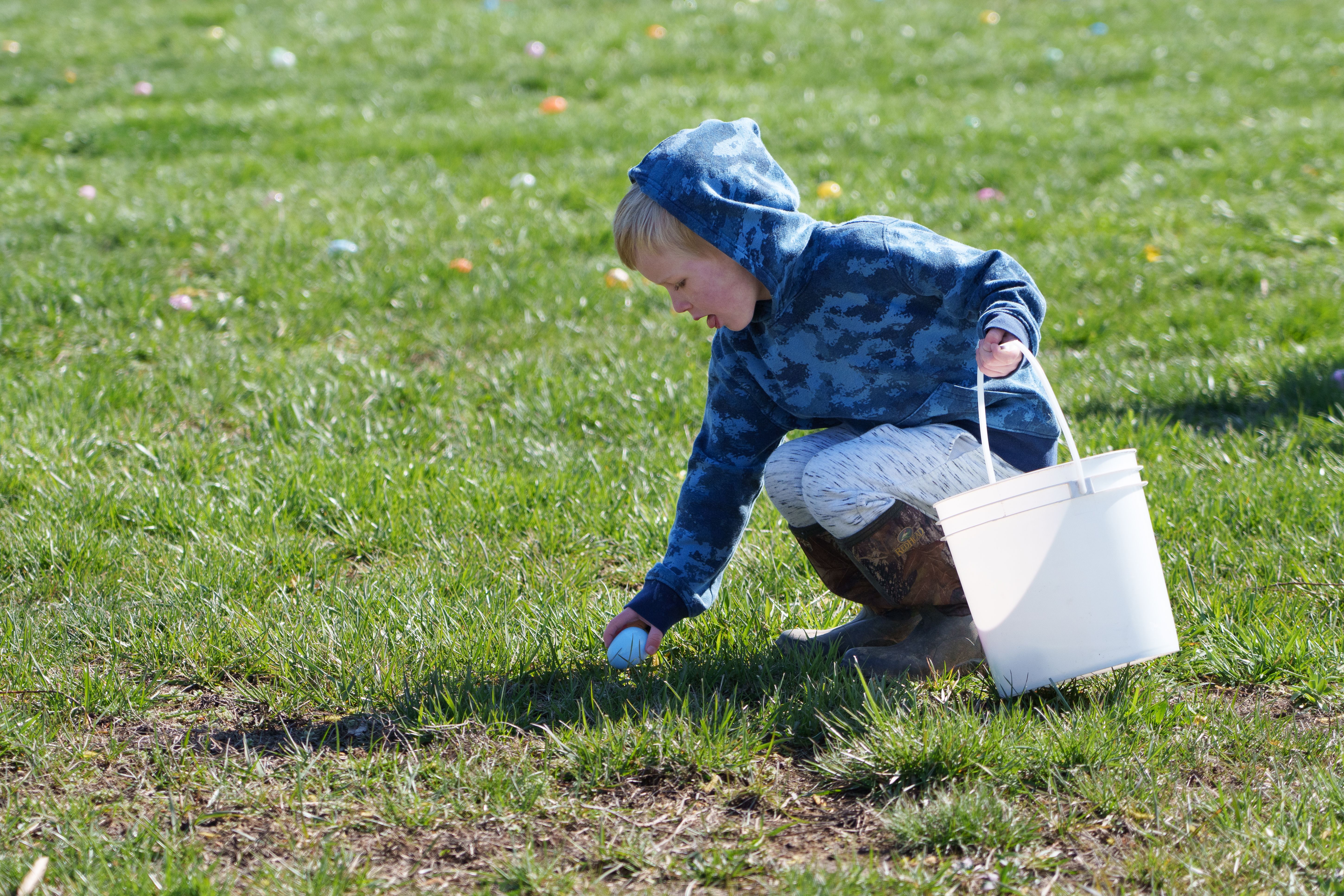 Photo of a child picking up a plastic egg