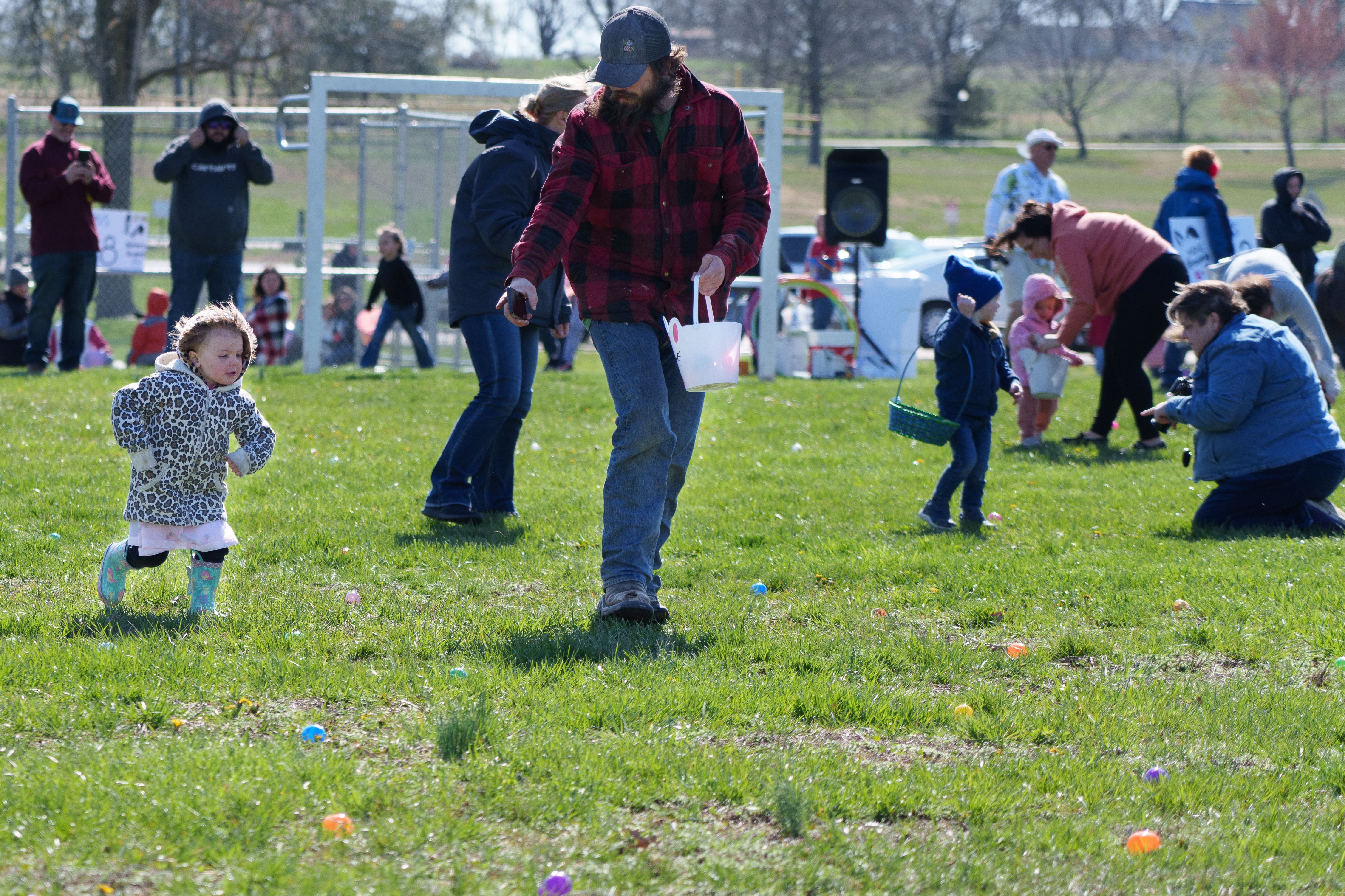 Photo of an adult pointing out eggs to a young child